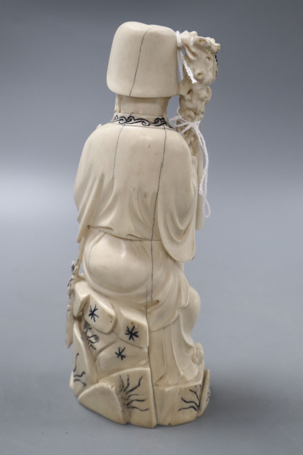A Chinese ivory carving of a man holding flower
